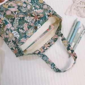 Détail du mini sac cabas en toile à imprimé floral et fermoir magnétique en bronze