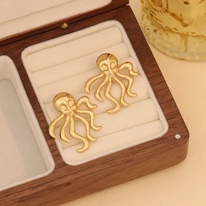 Polished gold octopus stud earrings in a luxury jewelry box with marine style design