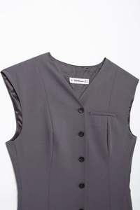 Detailed view of grey V-neck vest showing black buttons and neckline brand label