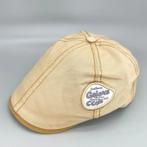 Detailed side view of khaki cotton beret showing vintage texture and embroidery patch