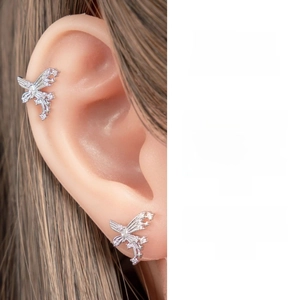 Macro shot of a silver butterfly cartilage clip earring with sparkling zircon stones