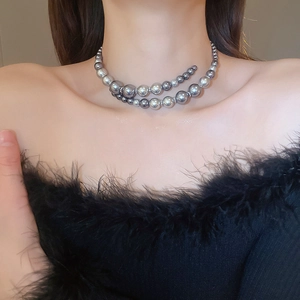 Detail of grey faux pearl necklace with metallic spacers shown on a model's neck