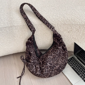 Detail of leopard print canvas crescent bag with side drawstring and adjustable strap