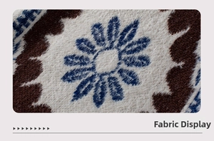 Macro shot of plush knit sweater fabric with vintage floral patterns and fringe details