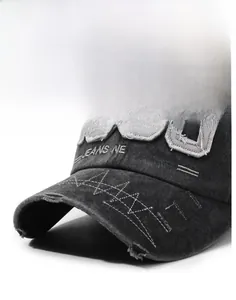 Close-up of distressed brim on vintage washed denim baseball cap with white embroidery