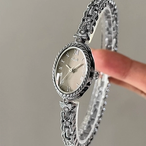 Montre-bracelet dorée pour femme avec cadran ovale argenté et bracelet métallique