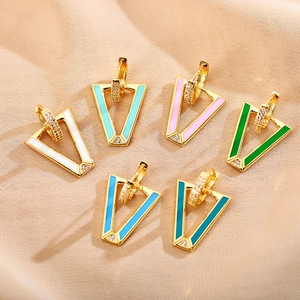 Macro detail of V-shaped geometric earrings with colorful enamel oil and small zircons