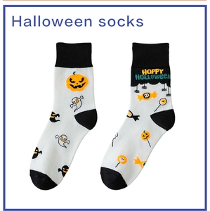 Detail of Halloween mid-calf socks with pumpkins and ghosts featuring Happy Halloween text