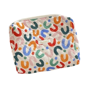 Quilted floral makeup bag with colorful abstract patterns and zip closure on white background