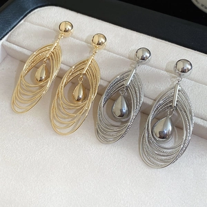 Detailed close-up of multilayer teardrop earrings in gold and silver plating