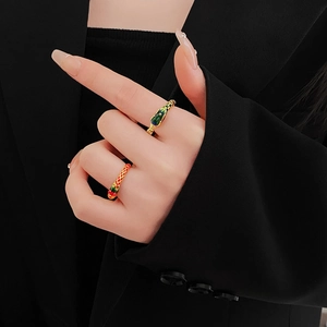 Detail of vintage gold dragon phoenix rings with red yellow patterns and green enamel