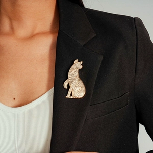Vintage gold metal puppy brooch with geometric texture pinned on a black suit lapel
