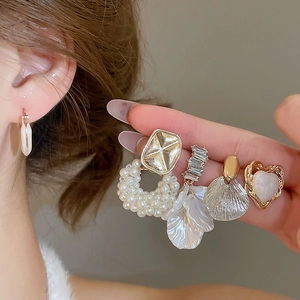 Detailed close-up of a 10-piece pearl and rhinestone heart earring set in elegant gold finish