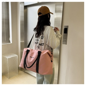 Pink waterproof oxford travel bag for gym and short trips worn by a female model