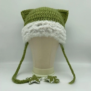 Close-up of handmade green cat ear hat with white faux fur trim and star star pendants
