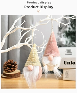 Detail of Christmas Gnomes with knit gold and pink plush hats hanging on white branches
