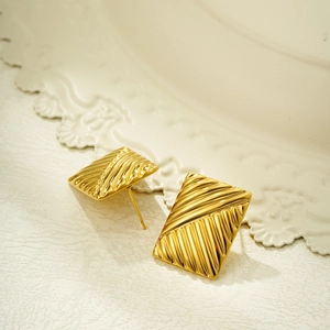 Macro shot of 18K gold plated rectangular earrings with unique wave texture detail