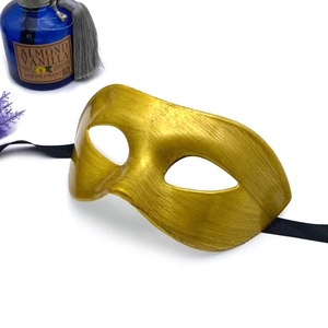 Golden masquerade mask with brushed metal texture and black ribbons for Halloween costume