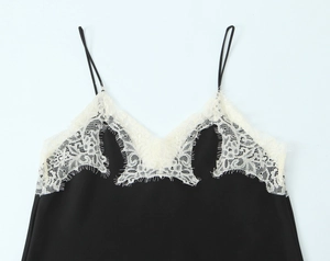 Detail of black satin camisole featuring delicate white lace trim and V-neckline