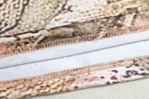 Close-up of snake print fabric showing precision stitching and quality textile texture