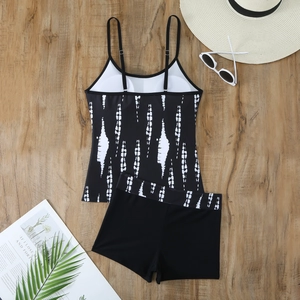 Flat lay of black and white striped tankini set with boy shorts on wooden background