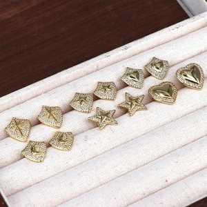 Close-up of gold star and heart stud earrings with cubic zirconia in a jewelry box