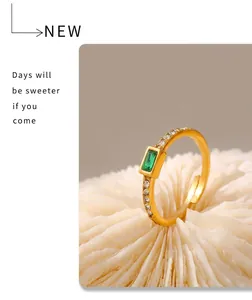 Detailed close-up of an 18k gold-plated ring featuring a green square glass stone