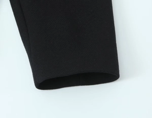 Close-up of the black wool blend coat sleeve cuff showing high-quality fabric texture