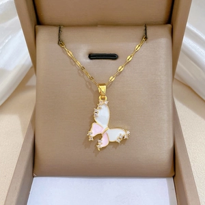 Macro detail of butterfly pendant with pink enamel wings and sparkling zircon inlay