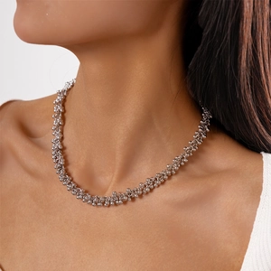 Close-up of minimalist silver beaded choker necklace featuring metallic ball strand textures