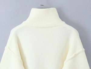 Detailed close-up of white high-neck knit cardigan with ribbed collar and soft fabric