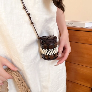 Detail of handcrafted mini cylindrical crossbody bag with coconut shell and white beads