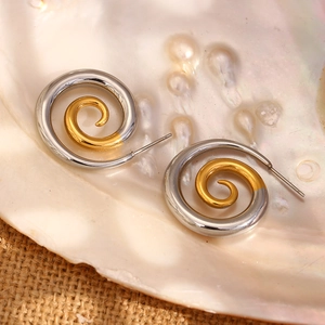 Macro de boucles d'oreilles spirales bicolores sur nacre et support en lin naturel