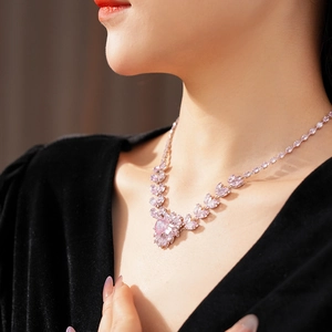 Gros plan d'un collier floral en cristal rose porté par un mannequin en haut noir