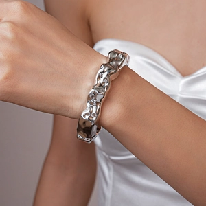 Close-up of irregular silver lava-style acrylic cuff bracelet on a model's wrist