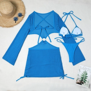 Flat lay of blue crochet swimwear set with cover-up top, drawstring skirt and bikini
