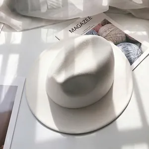 Detail of white wide-brim wool fedora hat with elegant stitching and a classic indented crown