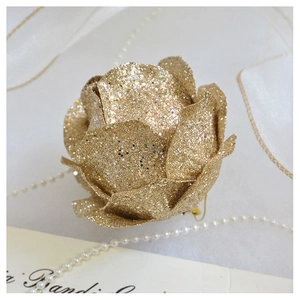 Close-up of champagne gold glitter rose ornament with elegant pearls and tulle