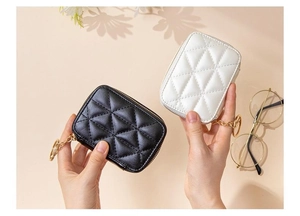 Close-up of black and white quilted mini cosmetic bags with gold hardware and mirror