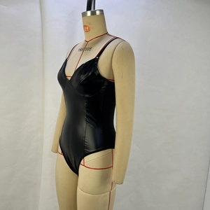 Détail d'une combinaison en cuir PU noir avec fines bretelles et décolleté en V profond