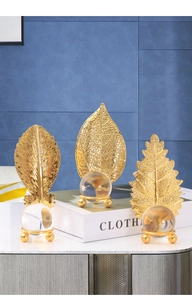Close-up of golden metal leaf sculptures and clear crystal balls for luxury home decor