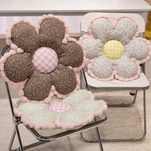 Floral plush seat cushions in vintage brown, green, and blue displayed on chairs