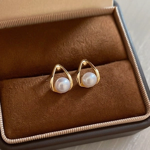 Detailed close-up of water drop pearl earrings in a luxury brown velvet jewelry box