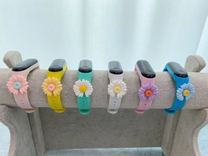 Six colorful silicone straps for kids watches with 3D daisy flowers on a velvet display