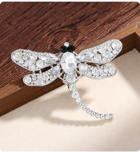 Detail of silver dragonfly brooch with sparkling rhinestones and marquise gemstones