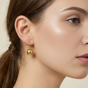 Polished gold ball drop earrings shown on model for elegant minimalist style
