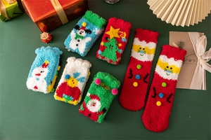Vue détaillée de chaussettes de Noël colorées en polaire corail avec ornements 3D festifs