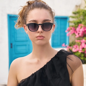 Detail of retro oval sunglasses with black frames and purple gradient lenses on a model