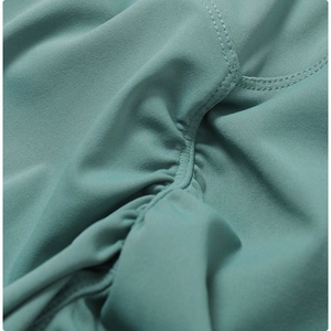 Macro detail of teal yoga shorts featuring ruched fabric and precision stitching
