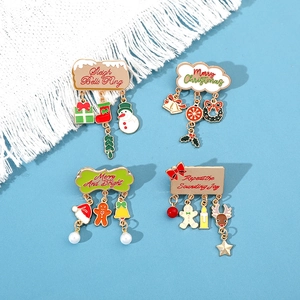 Detail of Christmas brooches with snowman and bell charms on blue background